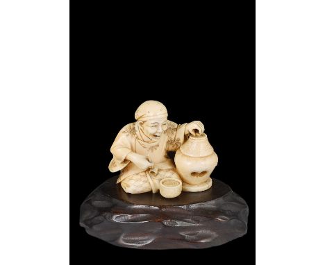 ˜A JAPANESE IVORY OKIMONO OF A PIPE SMOKER, MEIJI PERIOD (1868-1912) seated next to a jar, a pipe in his hand, stained detail