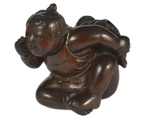 A JAPANESE WOOD NETSUKE OF A CHILD DOING BEKKAKO, LATE EDO PERIOD, CIRCA 1860 hiding a hozuki (cape gooseberry) fruit of inla