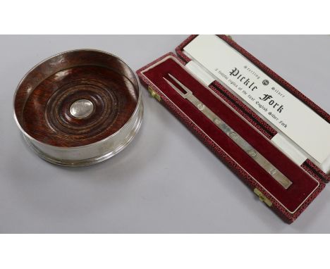 A modern silver commemorative wine coaster and a cased silver replica fork.