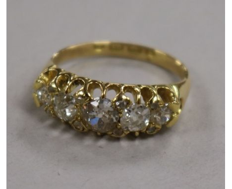 A late Victorian 18ct gold and graduated five stone diamond half hoop ring with rose cut diamond spacers, size K.