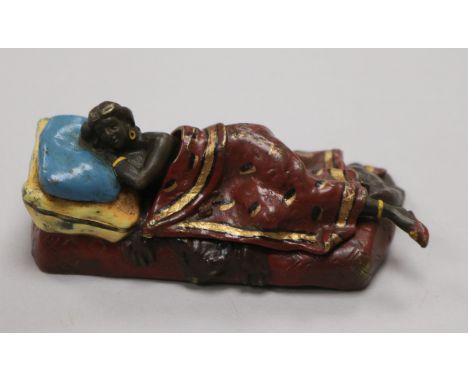 A cold painted bronze figure of a reclining figure
