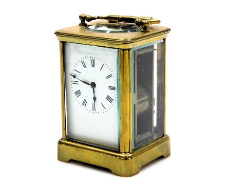 A brass carriage clock, rectangular enamel dial bearing Roman numerals, twin barrel movement with coil strike, the case of co