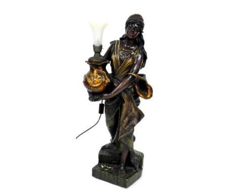 A late 19thC figural plaster torchere, of an exotic peasant woman, holding an oriental vase, raised on a stepped base, with a