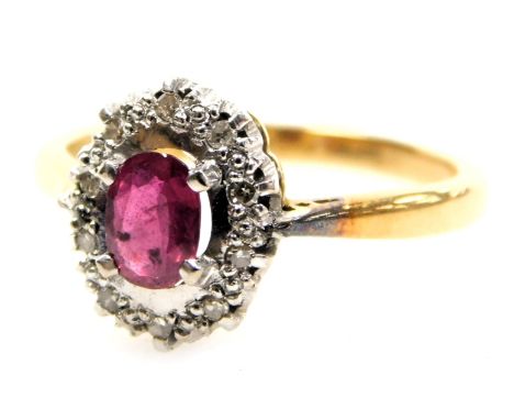 An 18ct gold ruby and diamond ring, the oval cut ruby in a basket setting with small diamonds, size O, 3.6g.