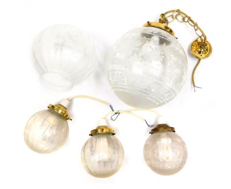 A glass ceiling light, of globular form, with floral decoration, 30cm high, three smaller pendant lights, of similar form, 19