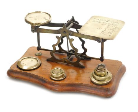 A set of early 20thC brass postal scales, raised on a serpentine mahogany base, with weights, by John Read of Birmingham, 24c