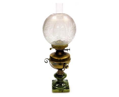 An early 20thC duplex brass and pottery oil lamp, with a brass reservoir, glass chimney and floral etched glass shade, 55cm h
