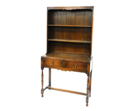 An early 20thC oak dresser, with a two shelf plate rack, above two frieze drawers, raised on turned legs united by a h frame 