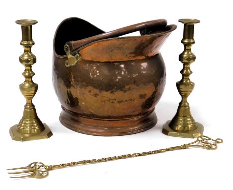 A Victorian copper helmet shaped coal scuttle, 35cm wide, pair of brass candlesticks, 27cm high, and a brass toasting fork. 