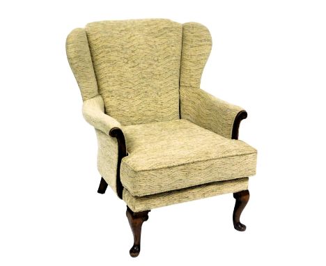 A Parker Knoll mahogany wing back arm chair, upholstered in wavy button back oatmeal fabric, raised on cabriole legs, 69cm wi