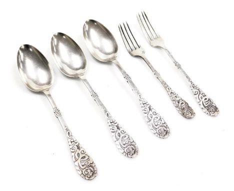 Three continental dessert spoons, with embossed stylised handles, together with a table fork and a dessert fork, white metal,