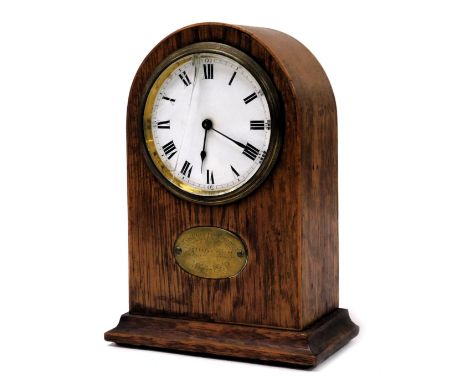 An early 20thC oak cased mantel clock, circular enamel dial bearing Roman numerals, Buren clockwork movement, the case of dom