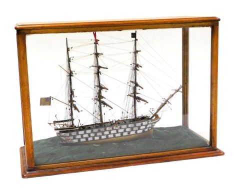 A wooden model of a late 18thC warship, three masted and fully rigged, on a sea base, mahogany cased, 46cm high, 64cm wide, 2
