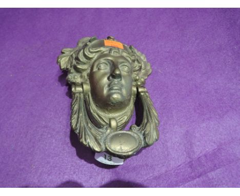 An antique heavy cast brass door knocker in the form of a Greek style goddess