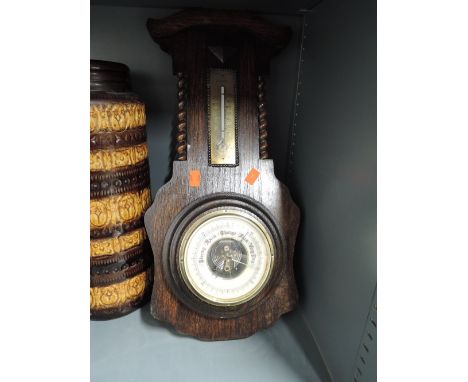 An early 20h century wall mounted barometer with enamel face and visible workings