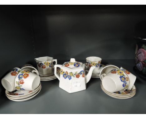 A vintage dolls house tea set with deco design and hand decorated print