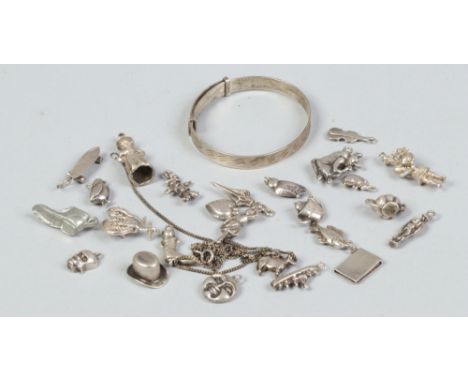 A quantity of silver and white metal charms along with a silver christening bangle.