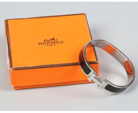 A boxed Hermes Paris Clic H bracelet with black enamel decoration.