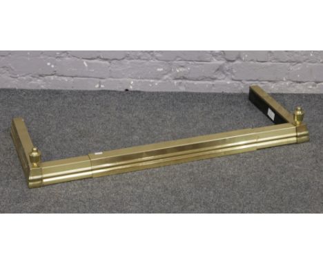 A modern brass effect adjustable fire fender with urn shaped finials.