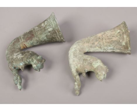 Two archaic bronze stirrup cups each surmounted by a wild cat.