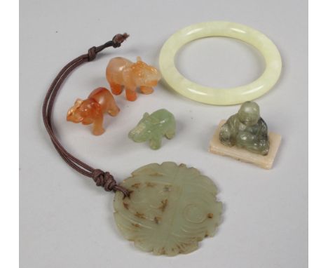 A box of jade and hardstone including bangle, pierced pendant, seated Buddha and two elephants.