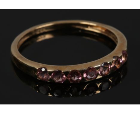 A 9ct gold dress ring set with seven pink tourmaline gemstones, size O.