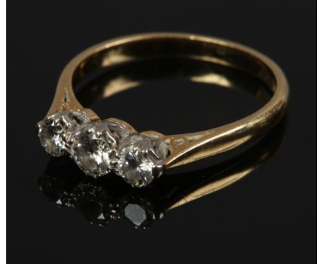 An 18ct gold three stone diamond ring set with brilliant cut stones, approximately 0.6ct total.