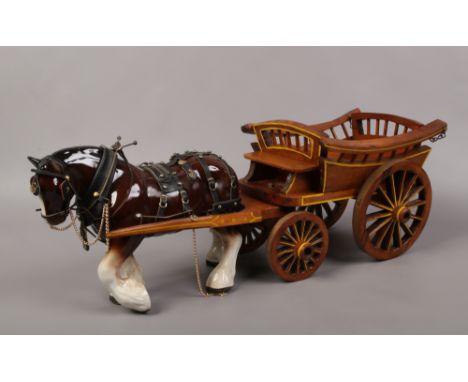 A large ceramic shirehorse in full harness and cart.