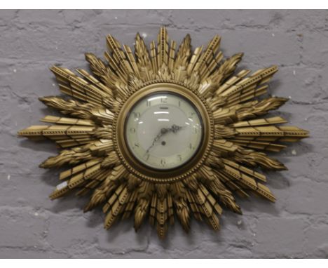 A Smiths gilt double sunburst wall clock.