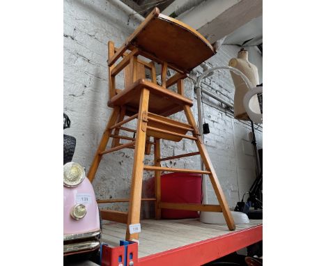 A child's wooden multipurpose high chair and a children's red pedal tractor 