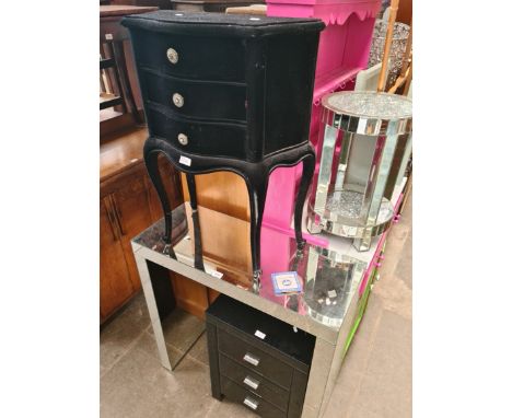 A modern mirrored glass side table, a black glass bedside cabinet and a black velvet beside cabinet. 