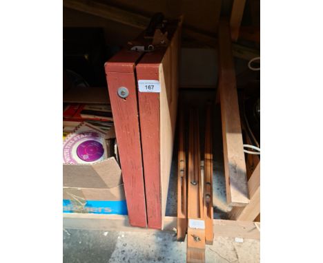 A case of artist's materials including paints and brushes and an easel