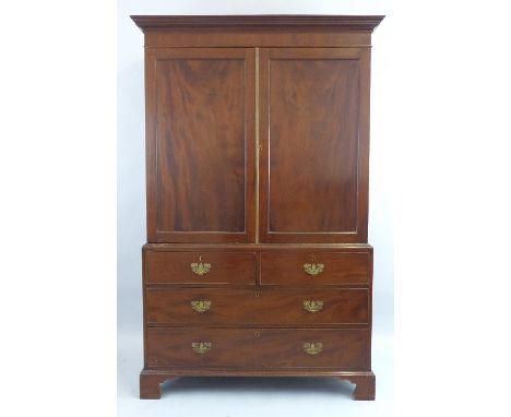 A 19th Century mahogany linen press, having flared cornice over two panelled doors enclosing shelves, on base with two short 