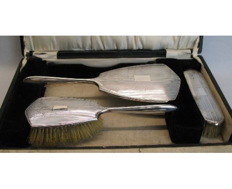 A three piece brush set, comprising clothes brush, hair brush and hand mirror, the hand mirror with bevel edged shield shaped