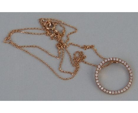 A diamond pendant, comprising an undulating ring of diamonds in 9ct rose gold suspended from a 9k rose gold trace chain, 45cm