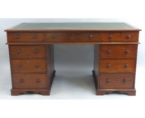 A mahogany pedestal desk, having leather writing surface over three frieze drawers on two banks of three drawers, turned knop