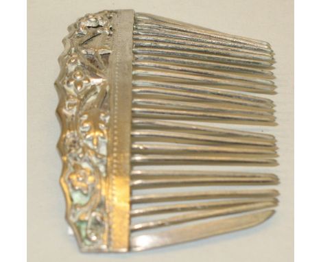 A Chinese white metal hair comb, of slightly curved form, moulded and pierced with stylised flowers and scrolling foliage, 8.