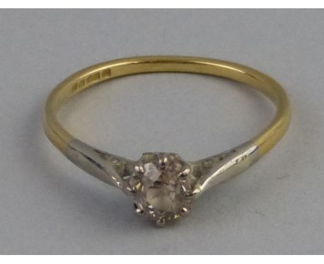 A solitaire diamond ring, the single stone claw set in 18ct white gold on 18ct yellow gold shank, size O