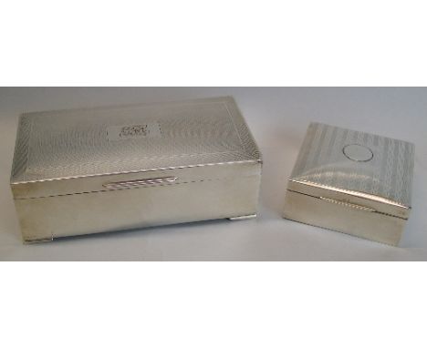 A cigarette box, of oblong form, the hinged engine turned lid with monogrammed cartouche, raised on short bracket feet, 17cm 