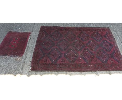 An Afghan rug, the central oblong panel with rows of diamond motifs and stars in black, ivory and yellow on a red ground with