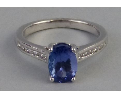 A tanzanite and diamond ring, comprising a central oval blue tanzanite (1.67ct) claw set on an 18ct gold shank with diamond s