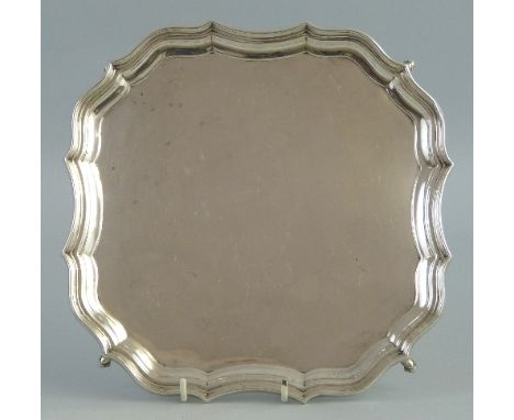 A waiter, of rounded square form with moulded Chippendale style rim, raised on scrolled bracket feet, 28cm wide, Chester 1912