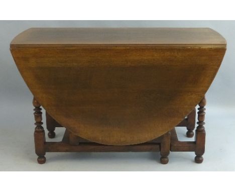 A 19th Century oak gate leg dining table, the oval top with shaped frieze opposing a frieze drawer, on baluster turned and bl