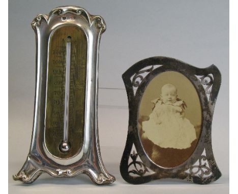 A photograph frame, of shaped oblong form with oval aperture surrounded by pierced scroll work, strut support missing, 11cm h