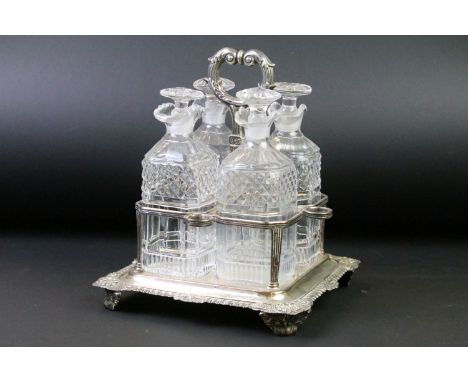 Late 19th / early 20th C set of four cut glass decanters &amp; stoppers raised on a silver plated stand with gadrooned border