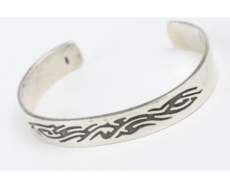 A contemporary 925 sterling silver open ended cuff bangle with engraved tribal decoration, marked 925 for sterling silver. 