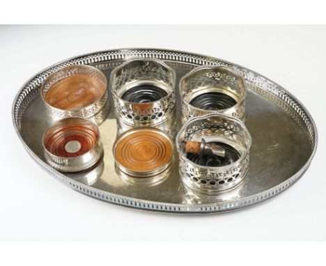 A large silver plated serving tray with decorative pierced edge together with a collection of silver and silver plated bottle
