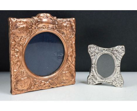 A hallmarked sterling silver easel back photograph frame together with a copper example with cherub decoration. 
