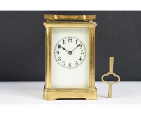 An antique 19th century brass cased carriage clock with beveled glass panels, complete with key. 