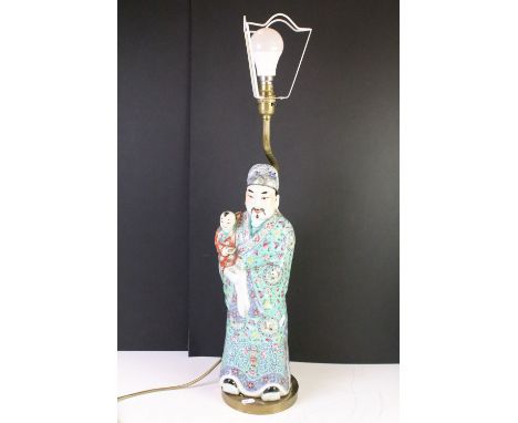 Chinese porcelain lamp base in the form of a man with baby each wearing coloured enamelled robes, raised on brass base with b